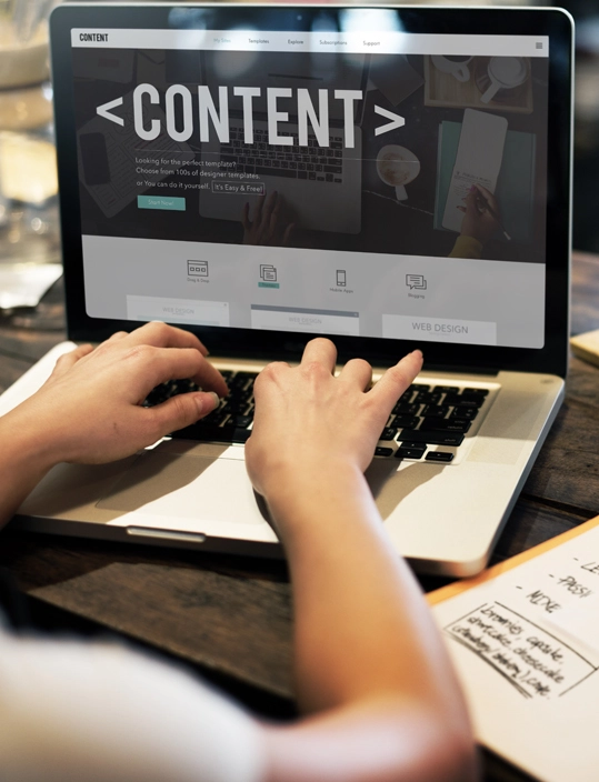 Visual representing content creation—laptop and notepad in use