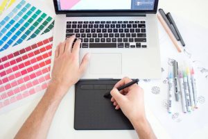 Designer working on a digital graphic project with color palette and screen open