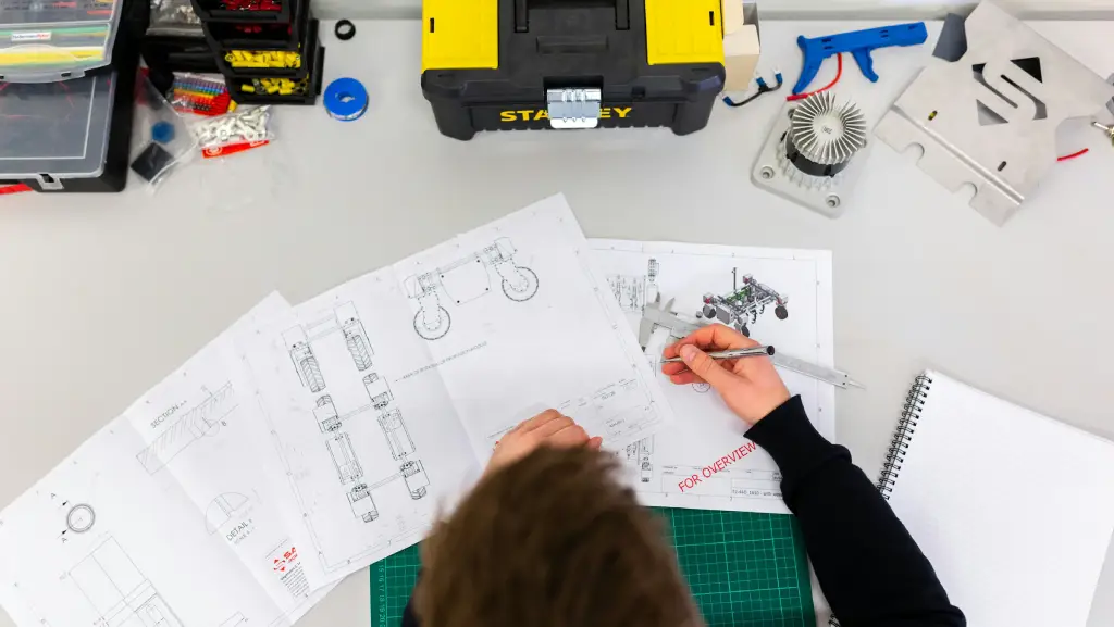 Professional designer working on detailed layout drawings, showcasing technical precision and visual planning skills.